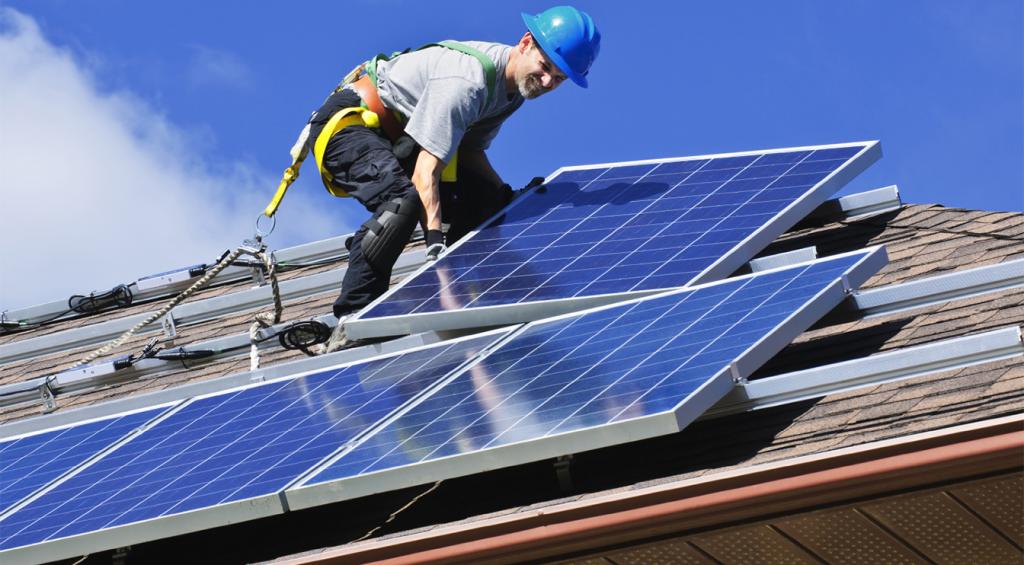man on a roof installing solar panels